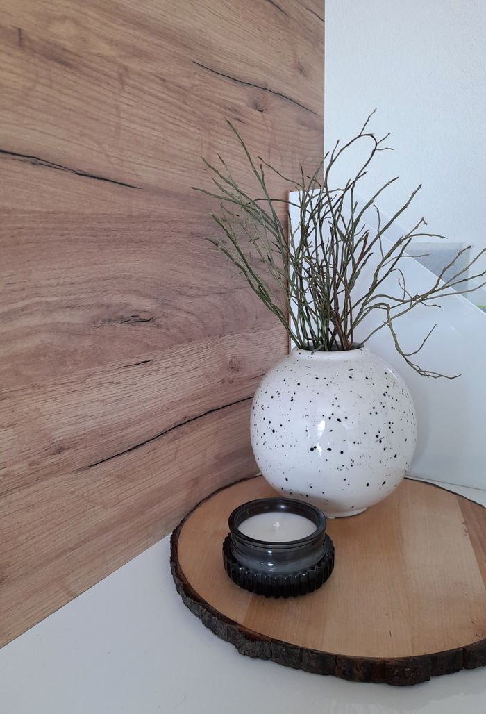 Chic interior scene featuring a ceramic vase with decorative branches on a wooden tray.