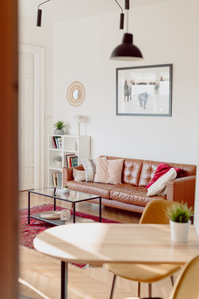 gallery-04 Stylish and cozy living room featuring a brown leather sofa, perfect for relaxing.
