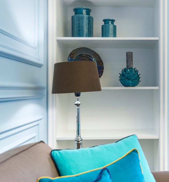 services-img Stylish interior with blue ceramics, brown lamp, and decorative pillow enhancing a cozy vibe.